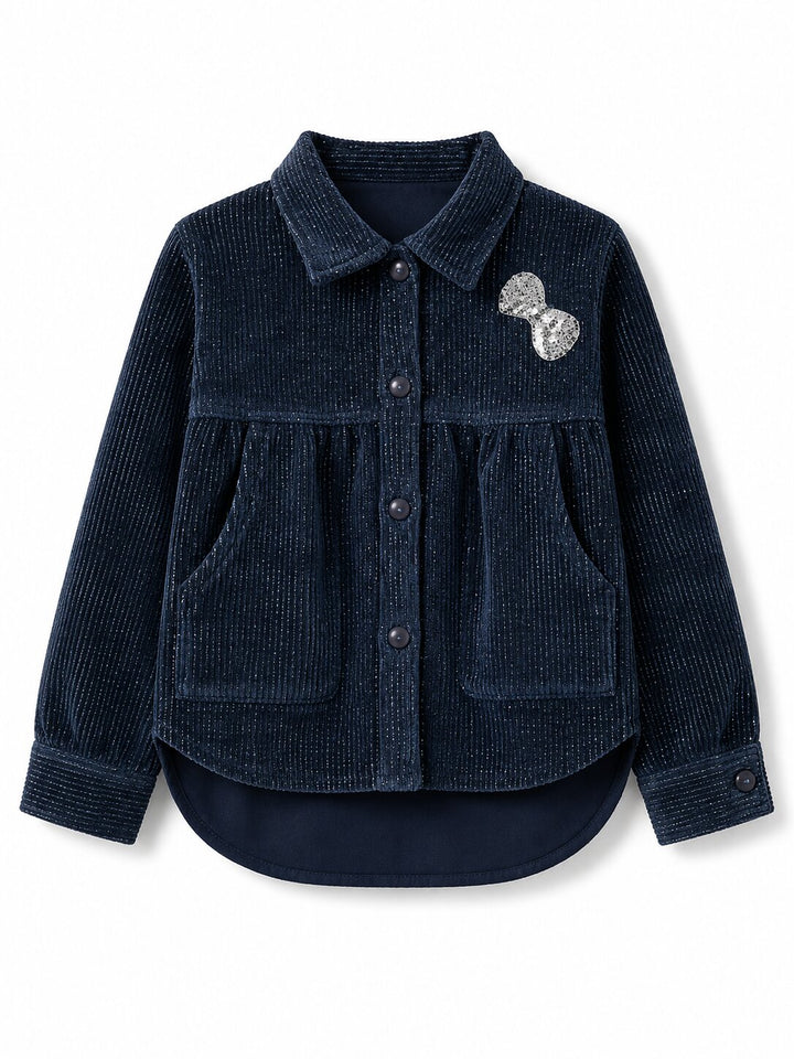 A dark navy blue corduroy button-up shirt jacket with a pointed collar, long sleeves, and two front patch pockets, featuring a silver sequined bow accessory on the left chest, shown against a plain white background.