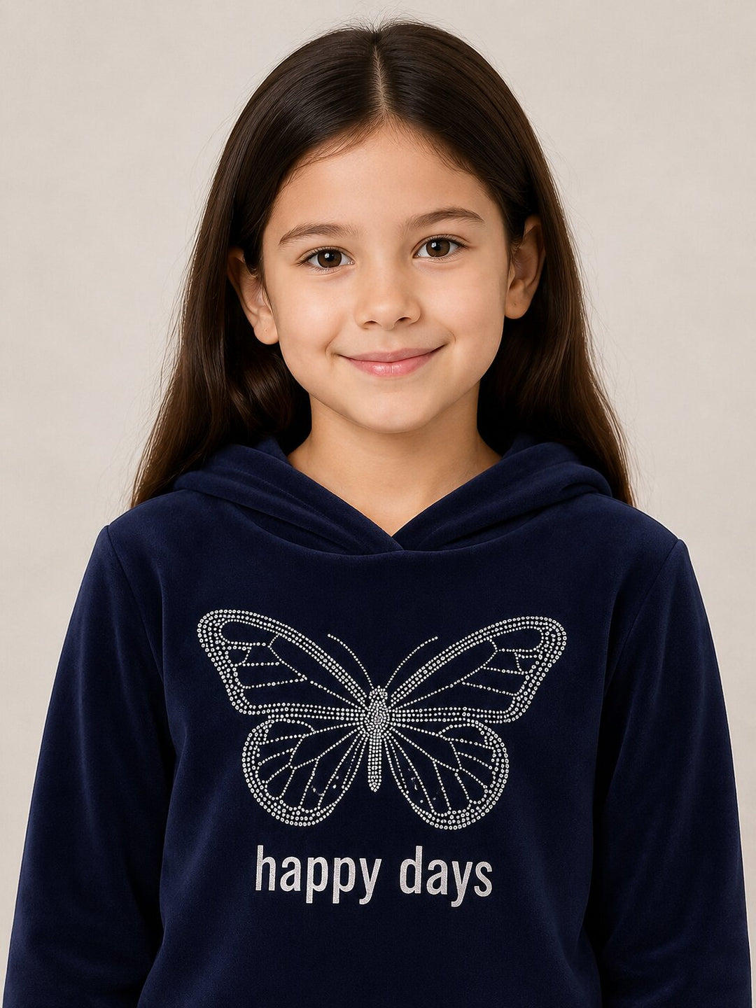 A young girl with long dark brown hair is wearing a navy blue hooded sweatshirt. The sweatshirt features a sparkling rhinestone-style butterfly graphic on the chest with the words 'happy days' printed below in white.
