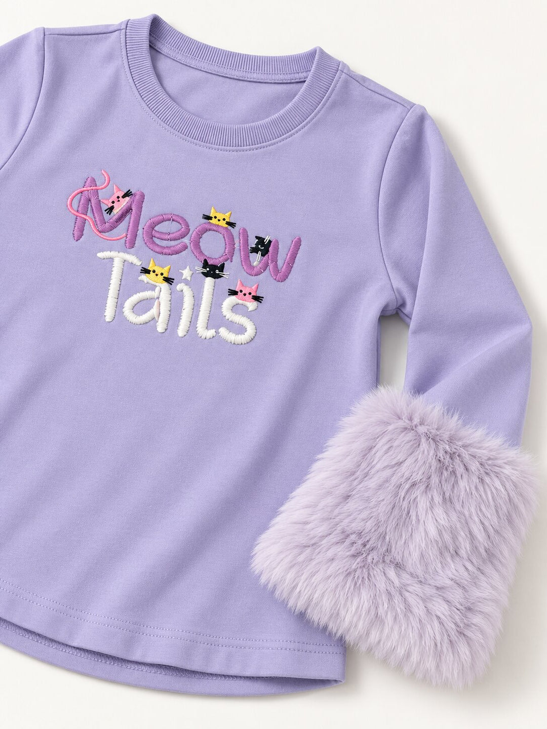 A lavender long-sleeve baby/toddler top with 'Meow Tails' embroidered on the chest, featuring small cat illustrations and a fluffy faux-fur cuff on one sleeve, shown on a light cream background.
