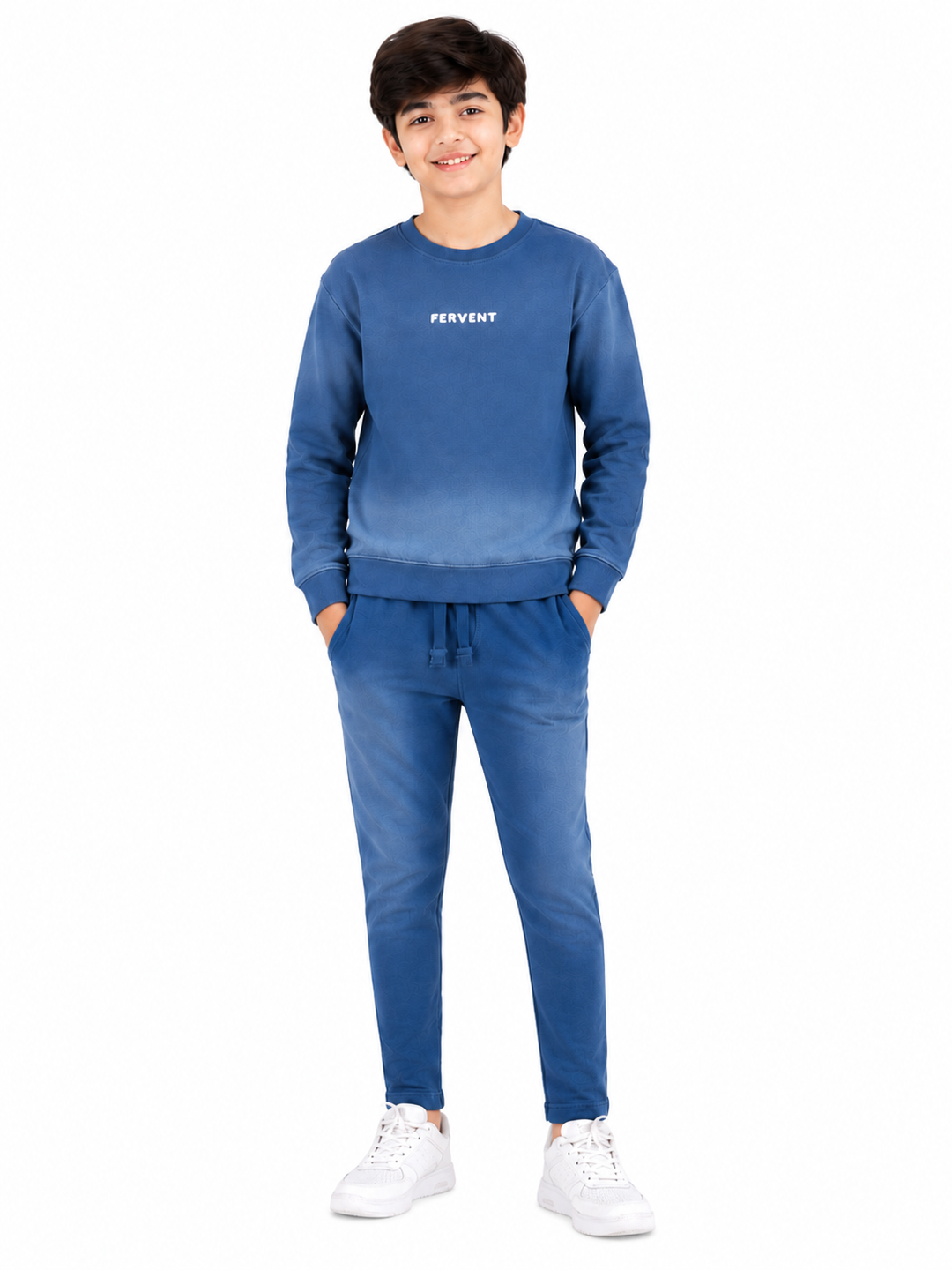 A young boy modeling a blue gradient sweatshirt and matching jogger pants set with white sneakers, standing against a plain white background.