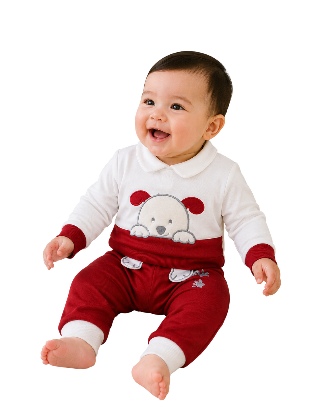 A smiling baby sitting and wearing a festive holiday-themed two-piece outfit. The set features a white long-sleeve top with a red collar, cuffs, and a white bear graphic on the chest, paired with matching red pants that have white cuffs and a small white snowflake detail.