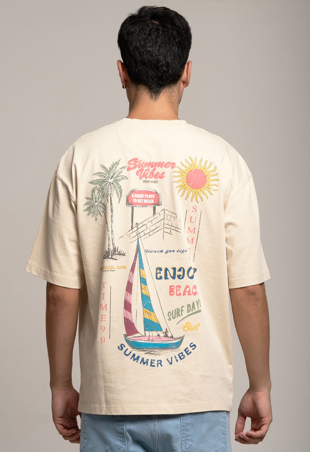 Person wearing a beige t-shirt with summer-themed graphics on a plain background