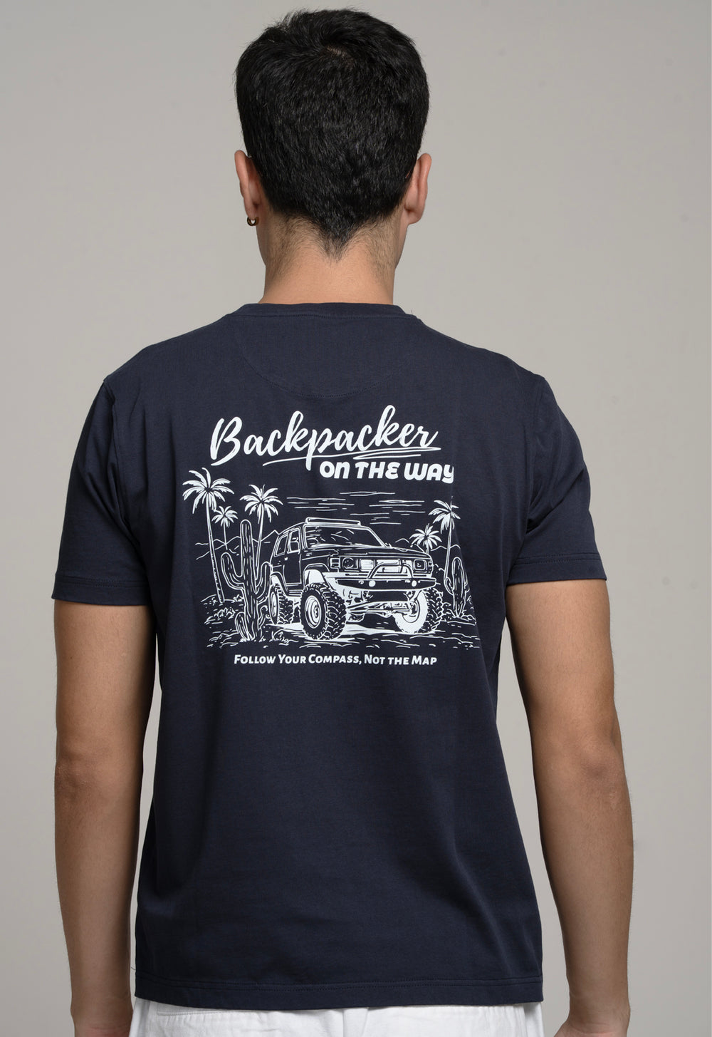 Person wearing a black t-shirt with a graphic design on the back, featuring text and an illustration of a vehicle.
