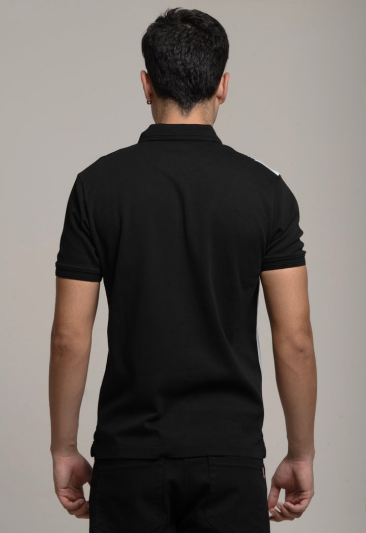 Man wearing a black polo shirt against a gray background