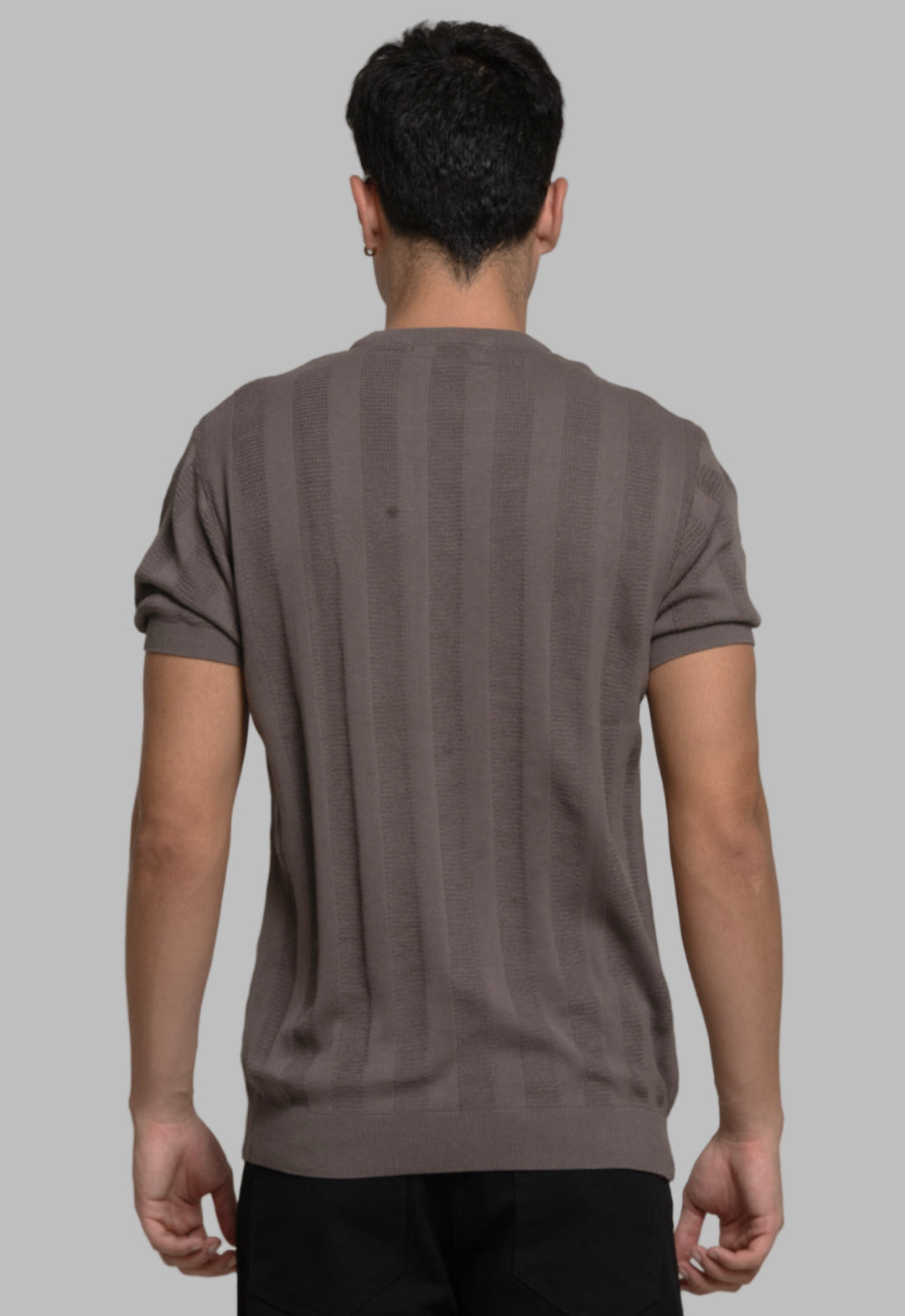 Person wearing a brown t-shirt against a plain background