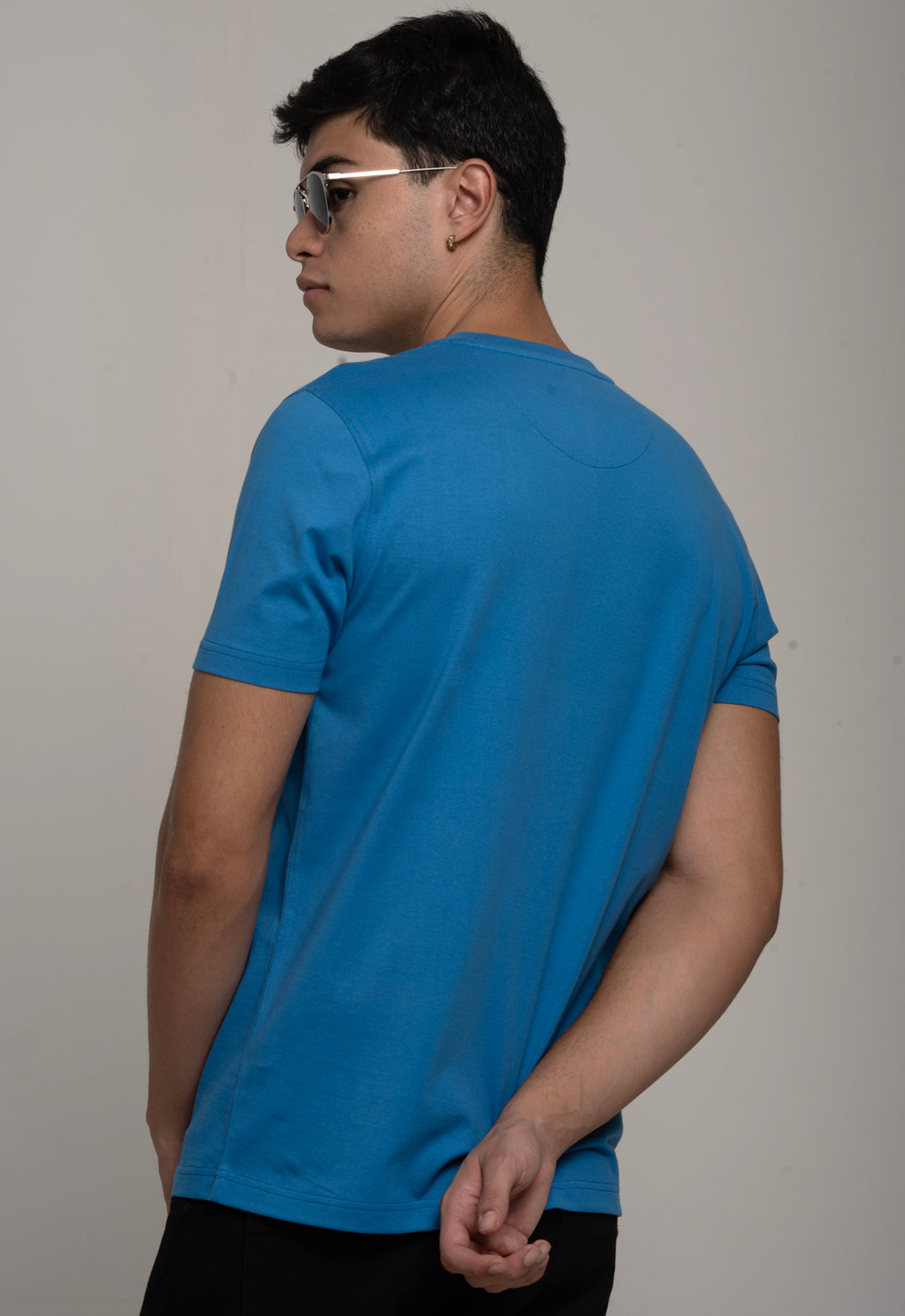 Man wearing a blue t-shirt against a plain background