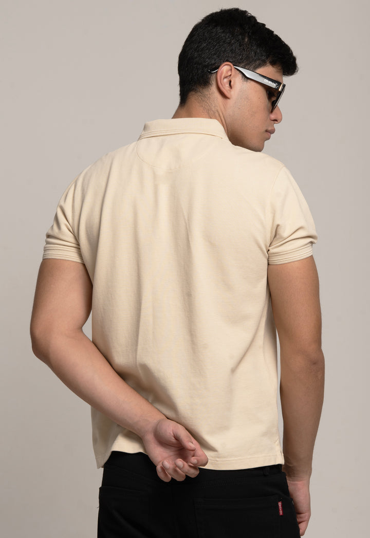 Man wearing a beige polo shirt against a plain background