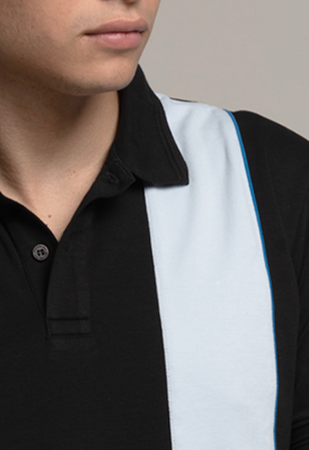 Close-up of a person wearing a black and white striped shirt with a neutral background