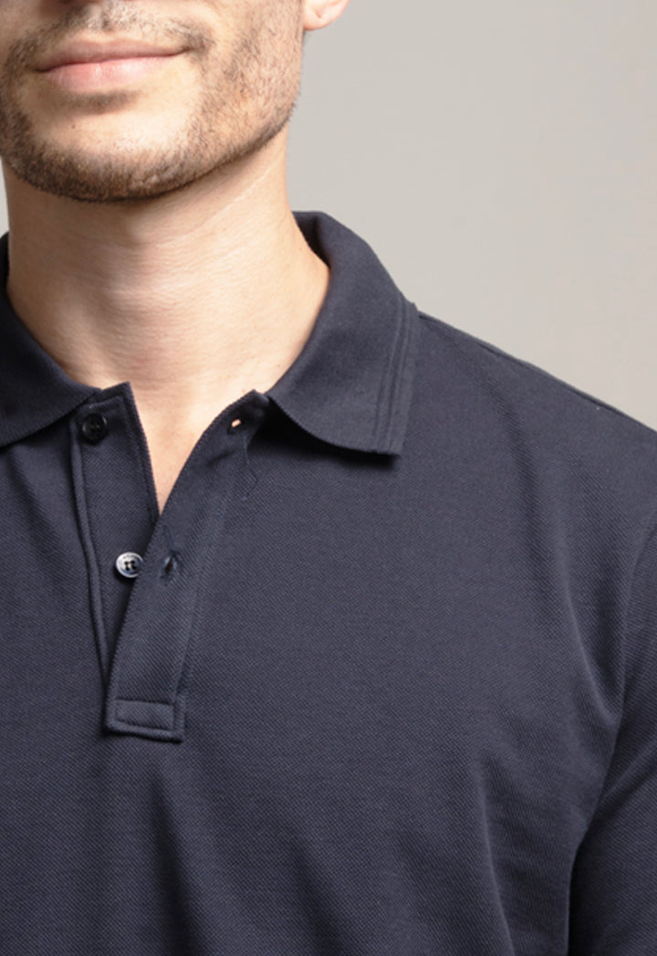 Navy blue polo shirt worn by a person on a gray background