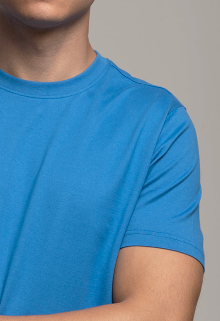 Blue t-shirt worn by a person on a gray background