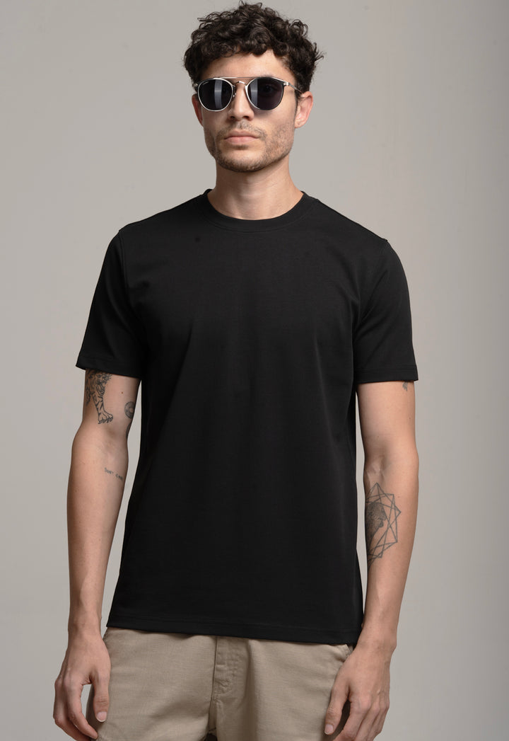 Man wearing a black t-shirt and sunglasses against a gray background
