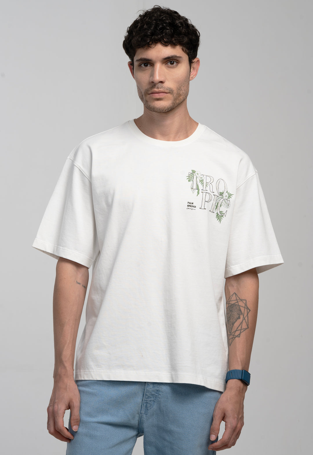 Man wearing a white t-shirt with a graphic design on a gray background
