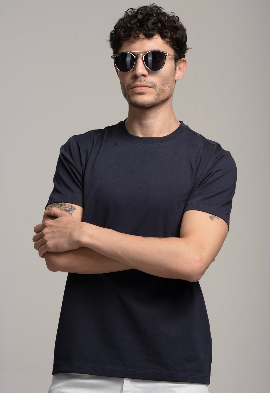 Man wearing a black t-shirt and sunglasses against a gray background
