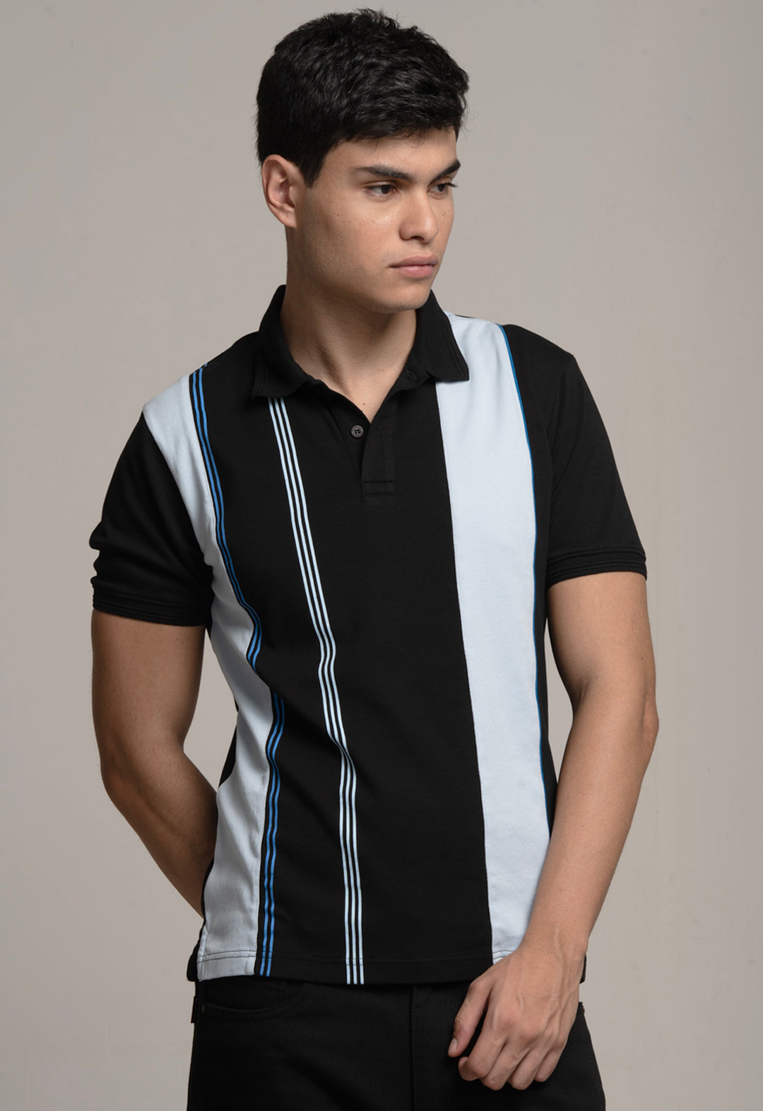 Man wearing a black and white striped polo shirt against a plain background