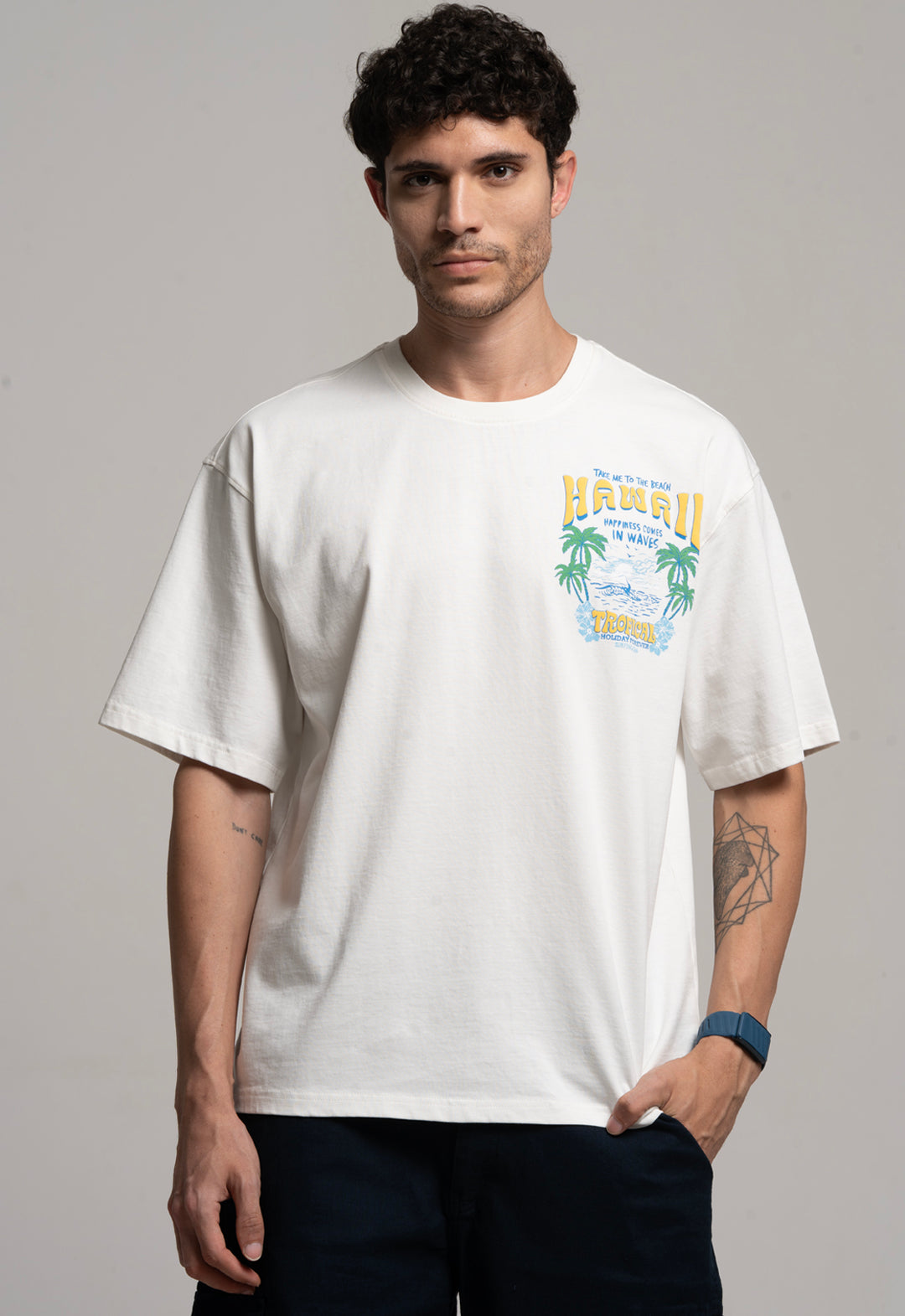 Man wearing a white t-shirt with a colorful graphic design on a gray background