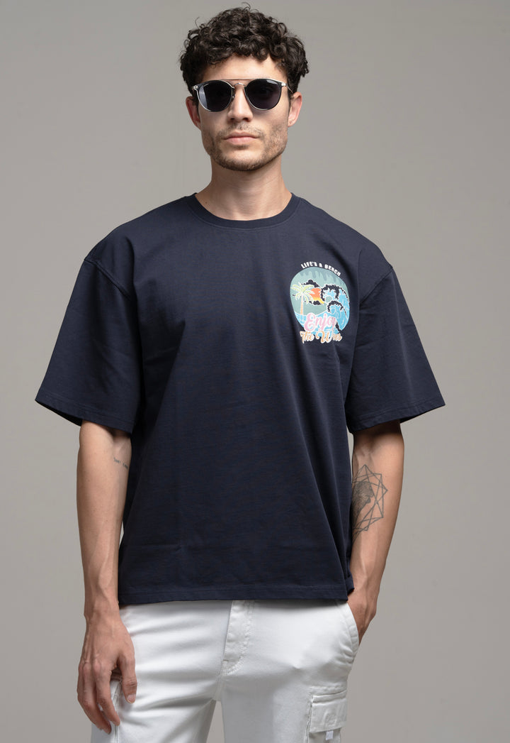 Man wearing a black t-shirt with a graphic design on a gray background