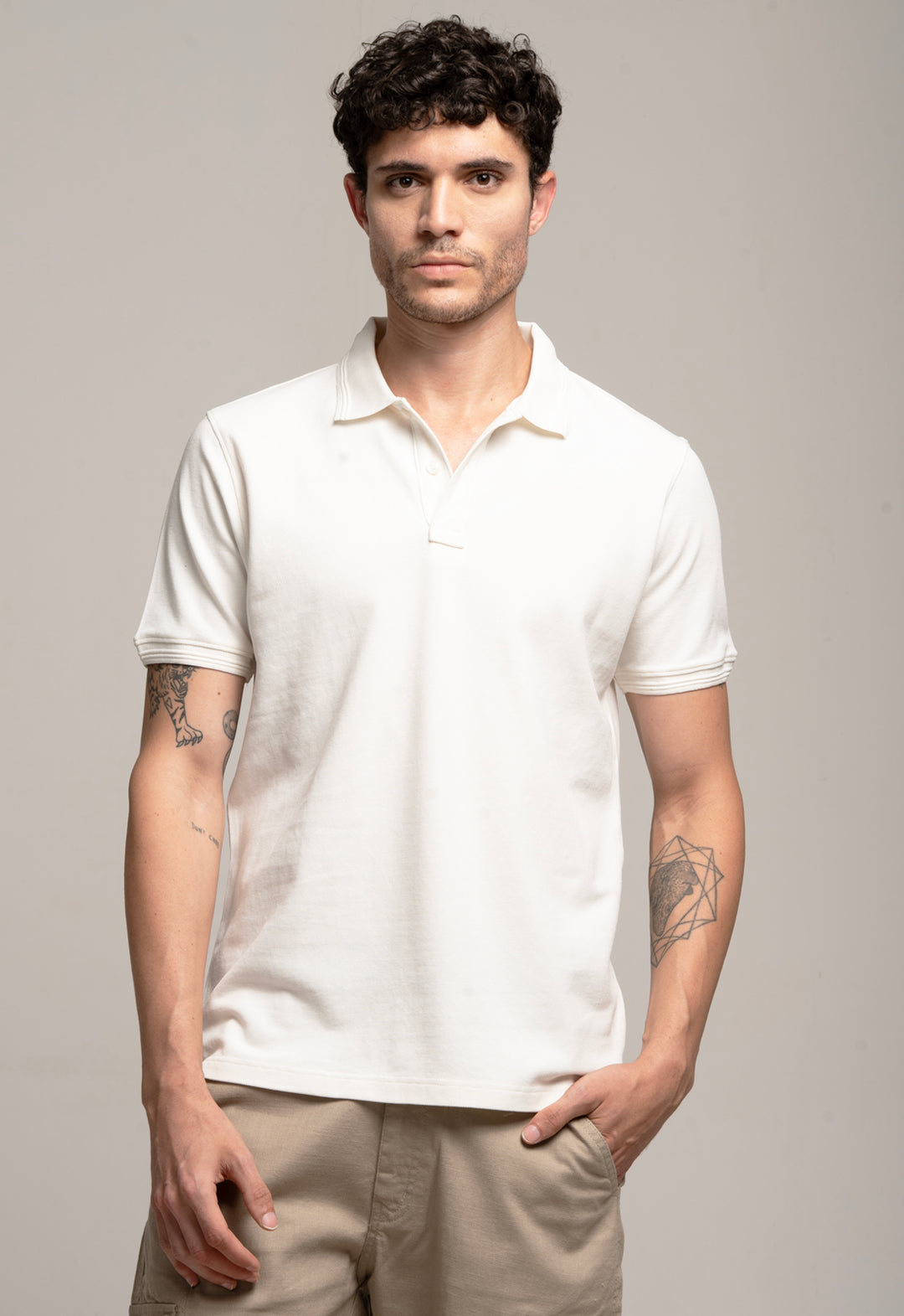 Man wearing a white polo shirt against a gray background