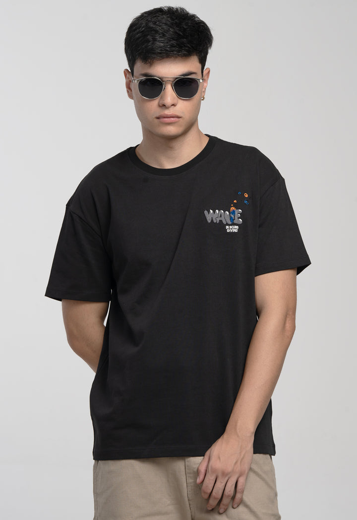 Person wearing a black t-shirt with a logo on a plain background