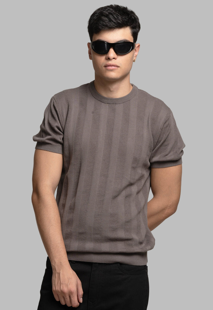 Man wearing a gray t-shirt and sunglasses against a plain background