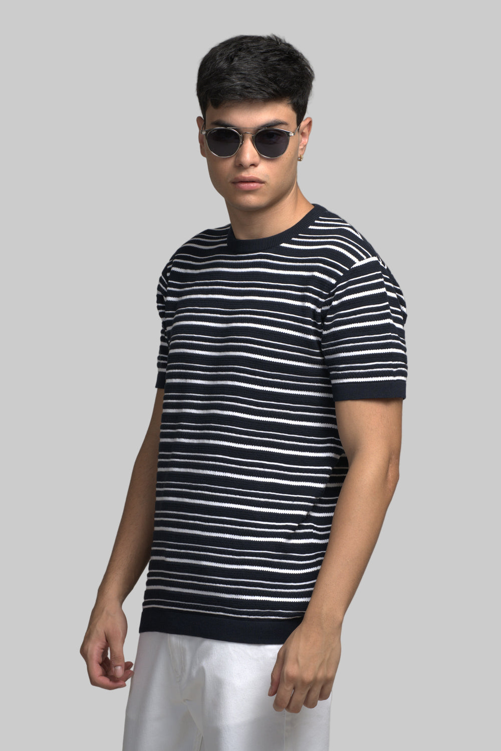 Man wearing a black and white striped t-shirt against a gray background