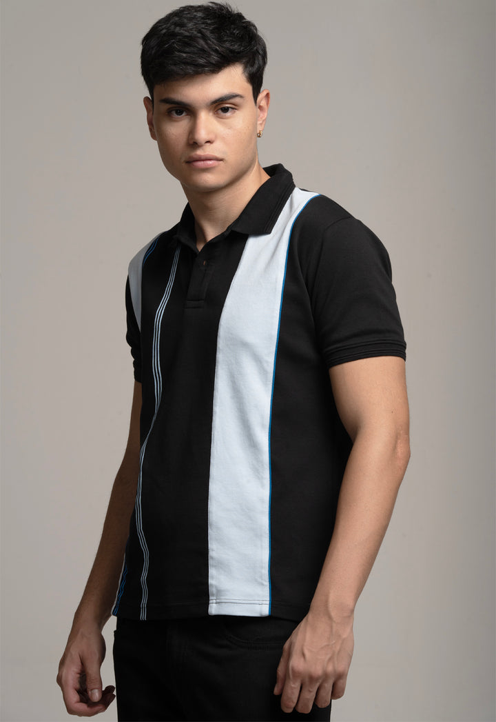 Man wearing a black and white striped polo shirt against a gray background