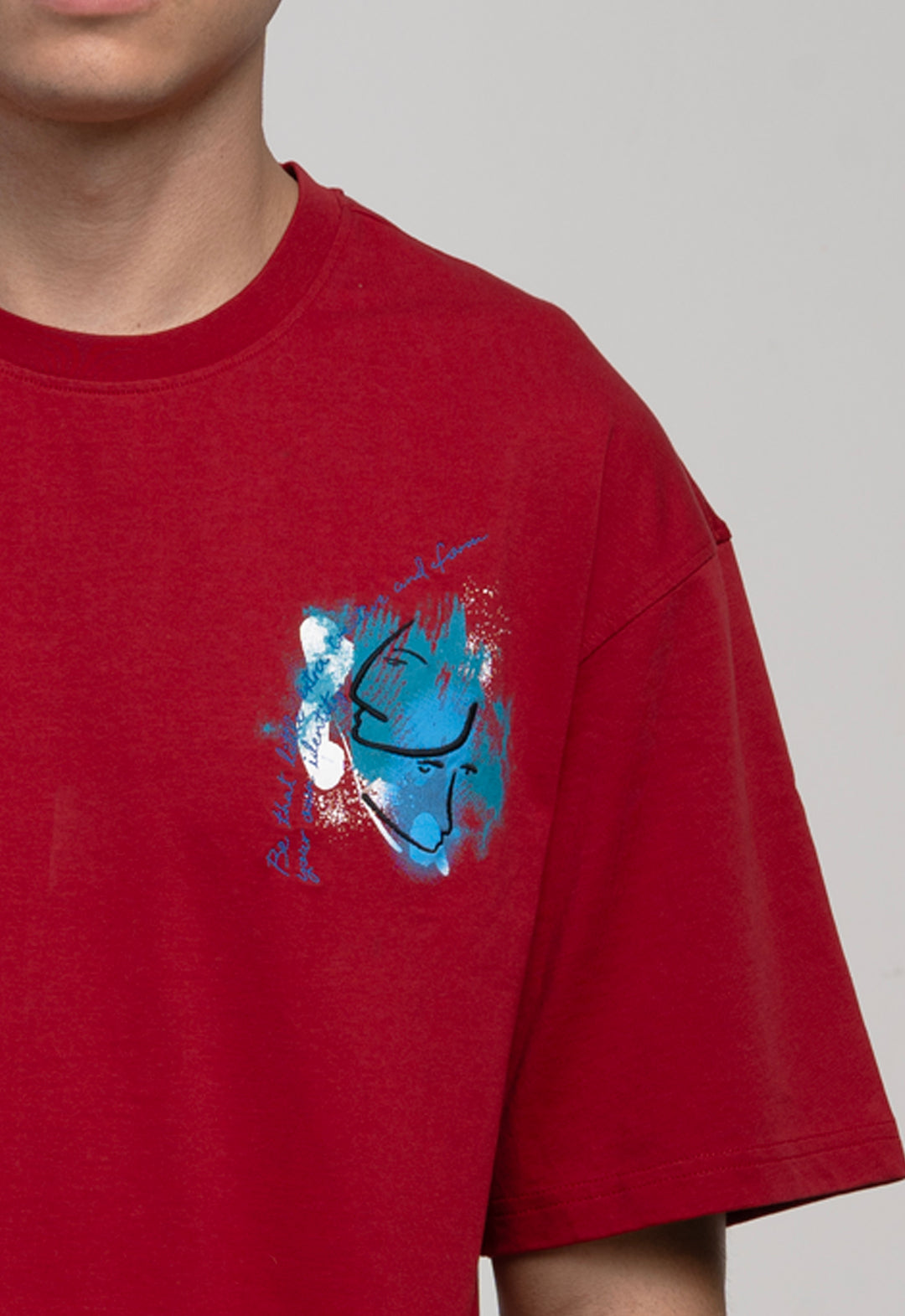 Red t-shirt with a blue graphic design on a plain background